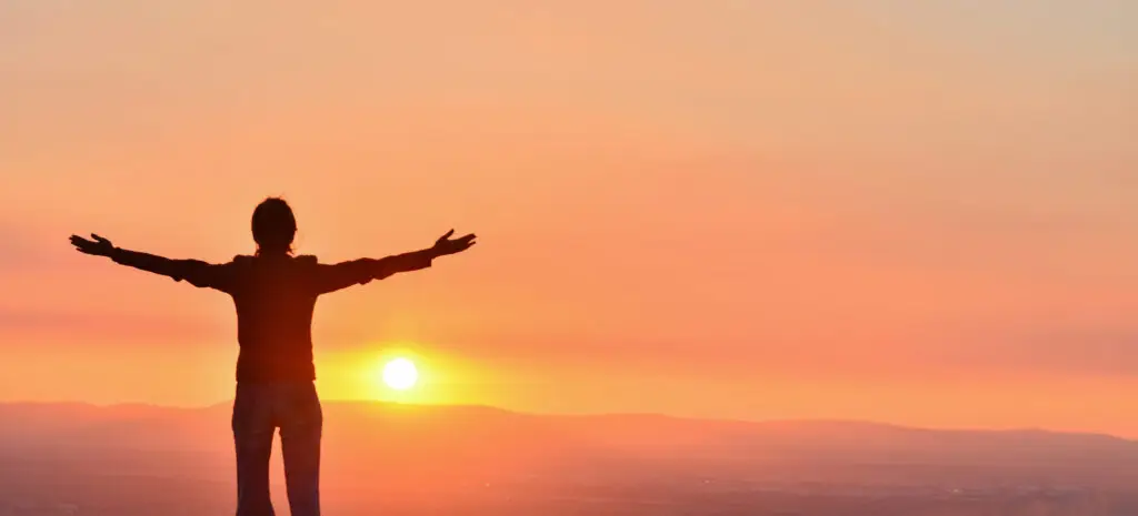 peak living of a person standing holding out there arms