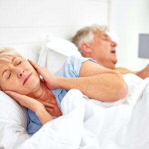 Snoring, problem and woman with frustrated with noise, sound or husband sleeping in bed with wife.