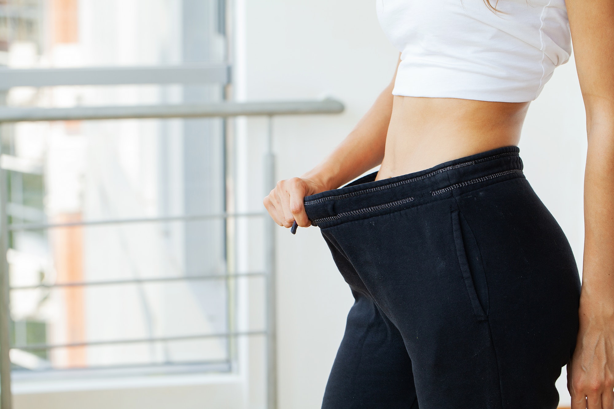 Woman in oversize pants after weight loss, diet concept.