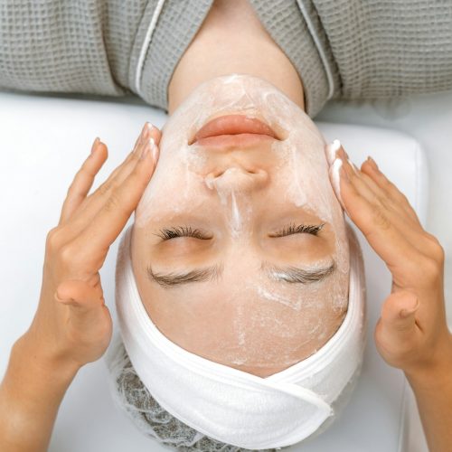 Top view on a pretty woman face during massaging skin with a special cream, scrub, peeling, to